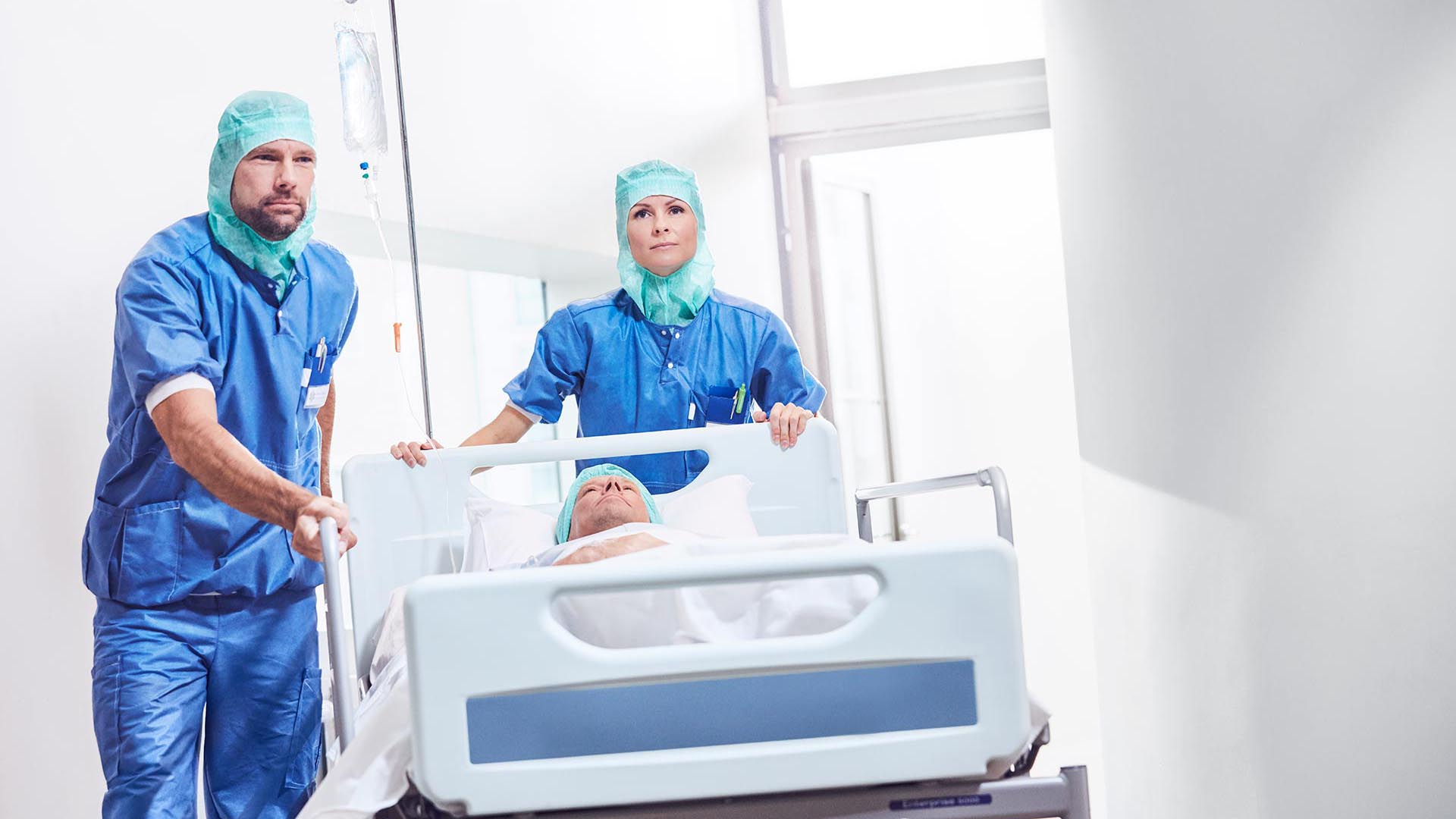 Professionnels de santé transportant un patient sur un lit mobile